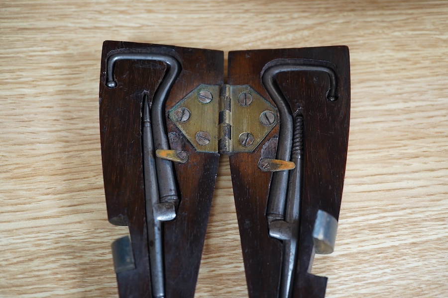 A Victorian rosewood 'ladys foot' etui holding a pair of steel bootpulls with additional tools to the handle, 26.5cm. Condition - good